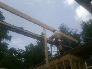 Carpenter setting a ridge beam over a new addition frame — Ice Dam Removal by Roofing Brothers in Saint Simons Island