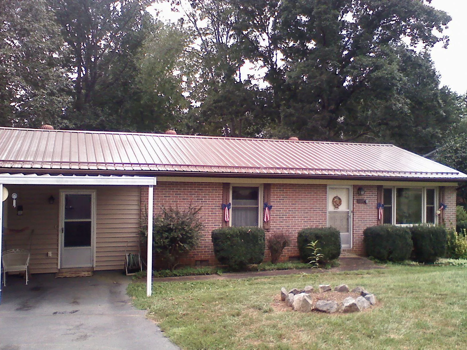 Bronze metal roof and carport on a brick ranch home — Roof Repair work by our crew in Saint Simons Island