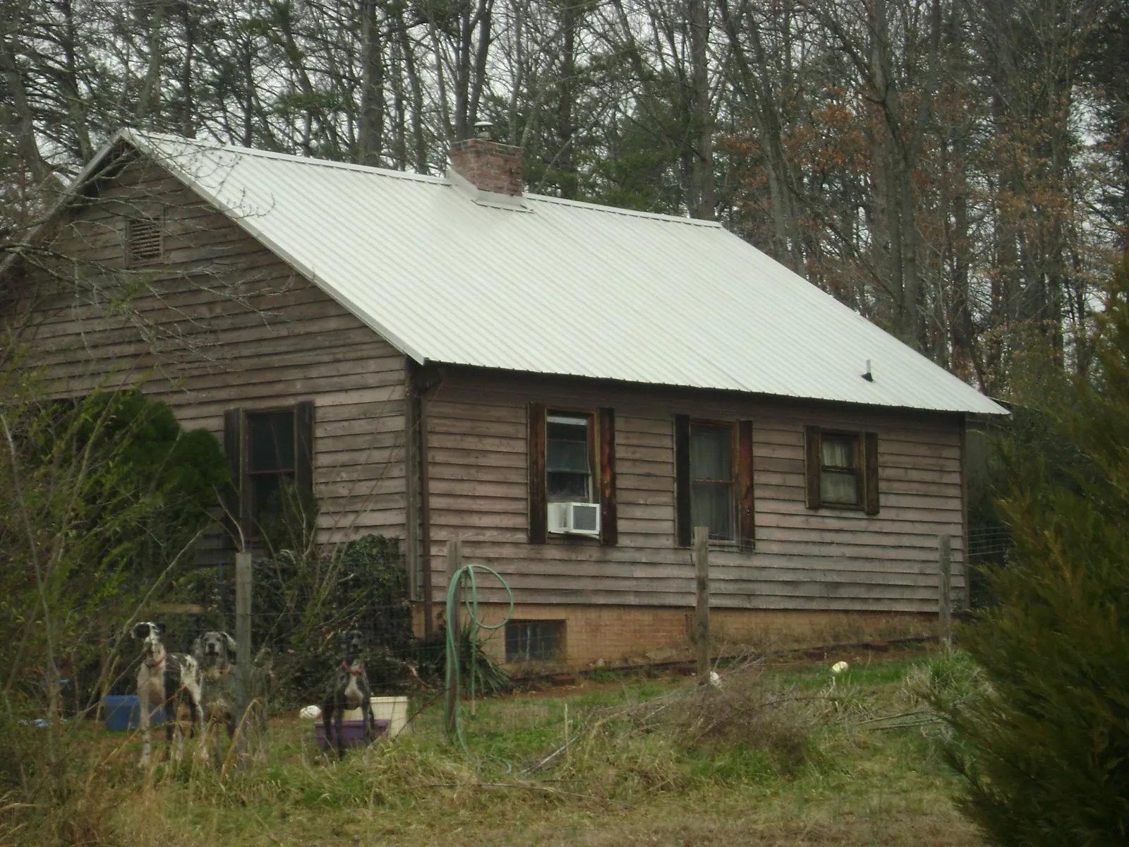 White metal roof on an old wood sided farmhouse, from a Metal Roof Installation job in Saint Simons Island